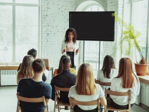 Female african-american speaker giving presentation in hall at university workshop