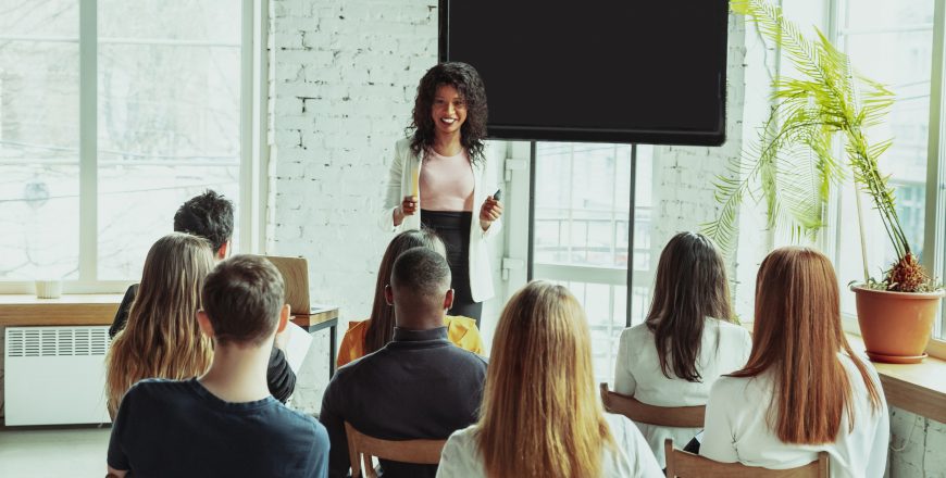 Female african-american speaker giving presentation in hall at university workshop